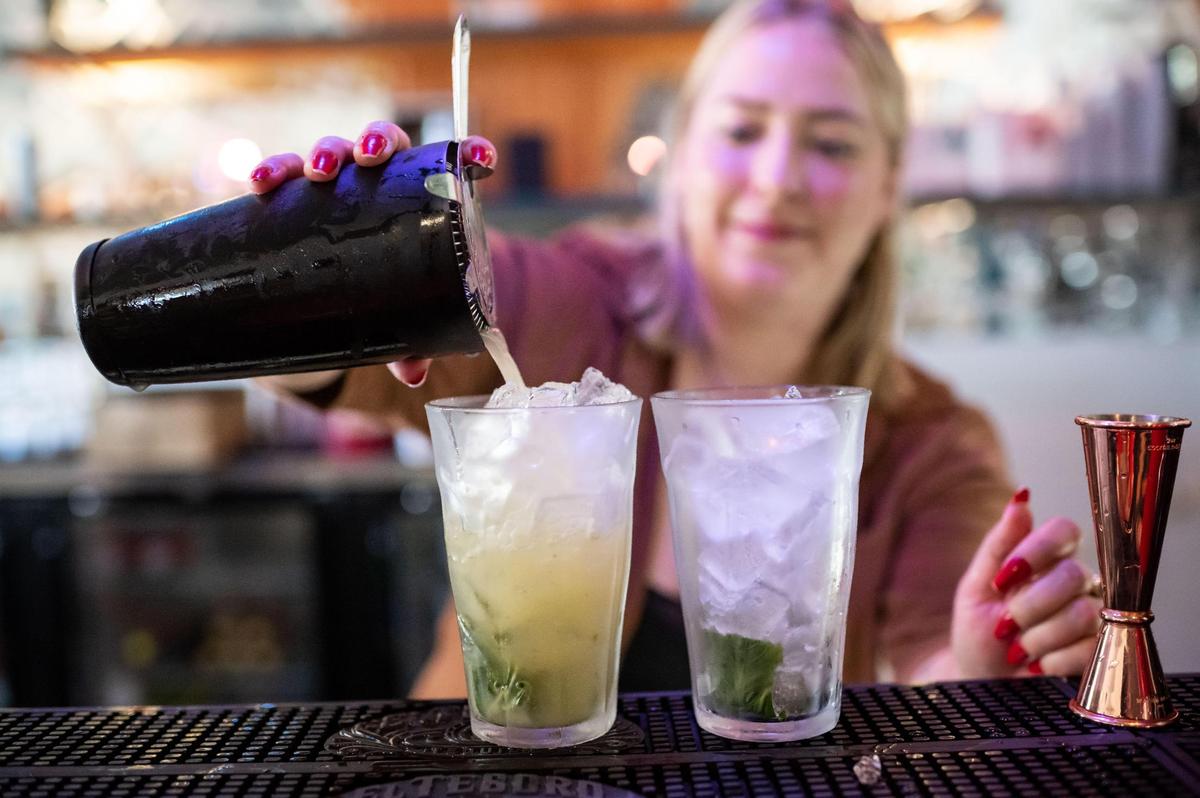 Bodega Kitchen & Cocktails bartender Kerri Sneve pours out two mojitos for a night of hosting friends and family Thursday before a grand opening Aug. 6.