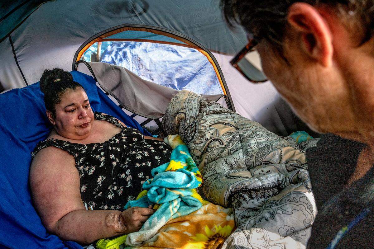 Tears stream down the face of Holly Porter, who is “functionally quadriplegic,” living in a homeless encampment, after she told Hope Cooperative’s case manager Tracey Knickerbocker that doctors told her she only has five years to live.