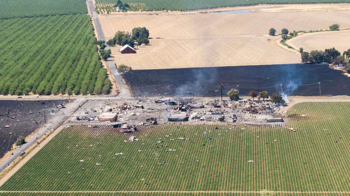 The fields surrounding a fireworks facility are littered with debris on Wednesday morning, July 2, 2025, the day after an explosion leveled the site near Esparto in Yolo County.