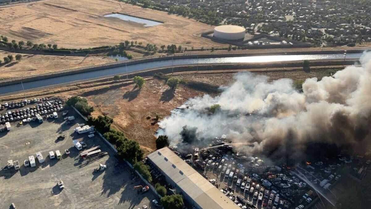 Heavy smoke rises from a fire at a salvage yard and adjacent grassland on Recycle Road, as seen looking west from a Metro Fire helicopter over Rancho Cordova on Friday. Multiple rows of tightly packed trucks and other commercial vehicles caught fire after the blaze was reported about 5:45 p.m.