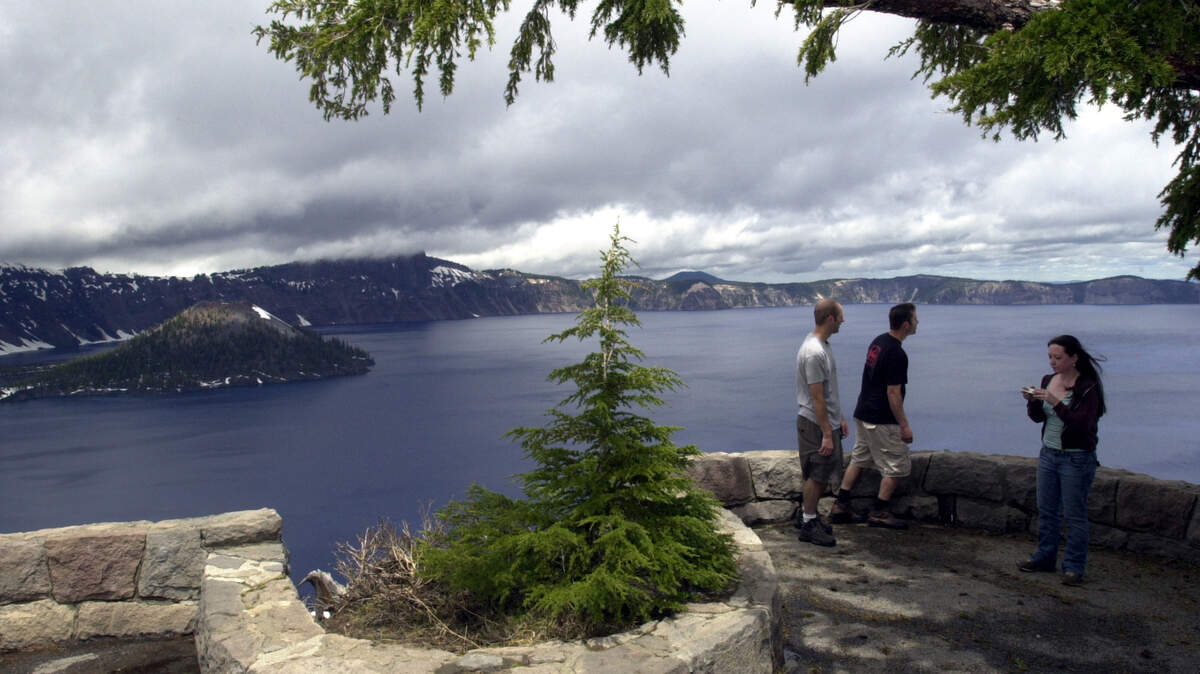 Tourists take in the view at Crater Lake National Park, Ore. , in 2006.