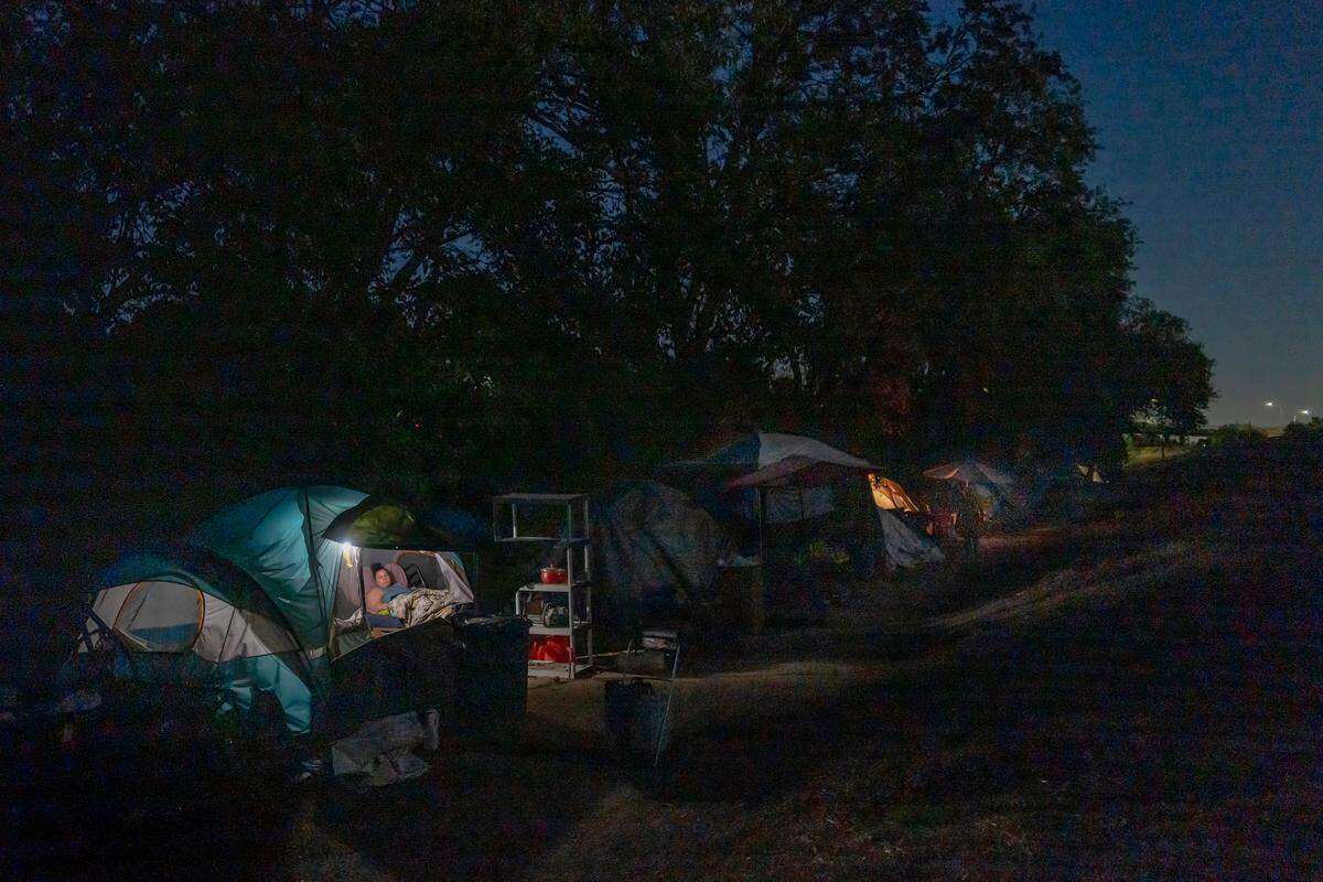Holly Porter lives in a tent along the American River in Sacramento in 2022, after she was swept in April from the Colfax Street encampment. She has since returned to the camp in North Sacramento. When she was on the river, she said she’d hear a disabled woman in a nearby tent “scream and cry every day in pain, and it killed me that there was nothing for her.”