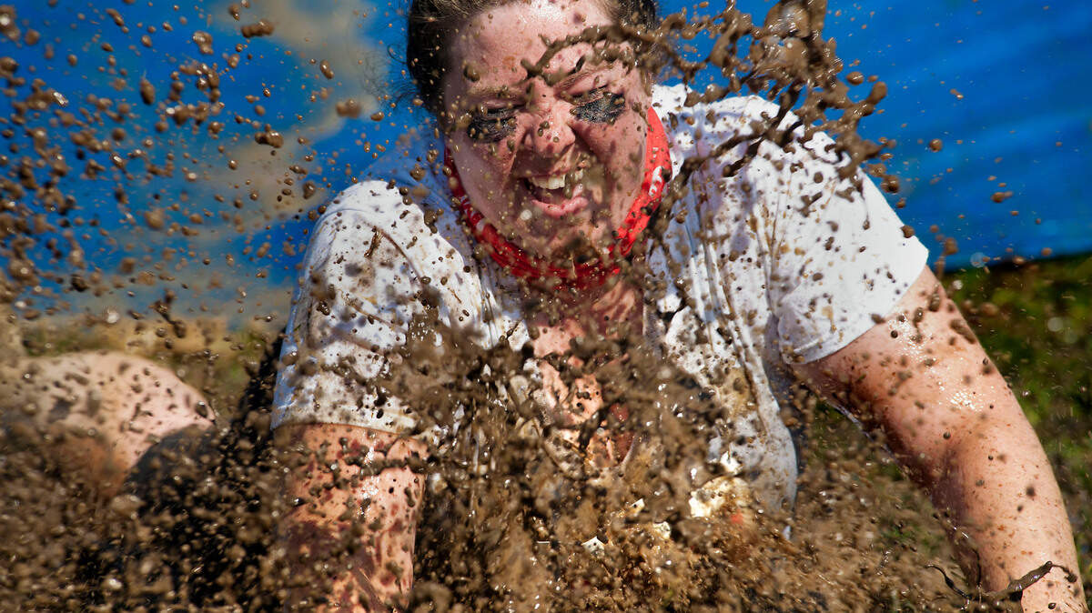 A woman slides head-first into a mud puddle obstacle at Gibson Ranch in Sacramento in 2012. The Mud Factor kicks off Saturday in Elk Grove.
