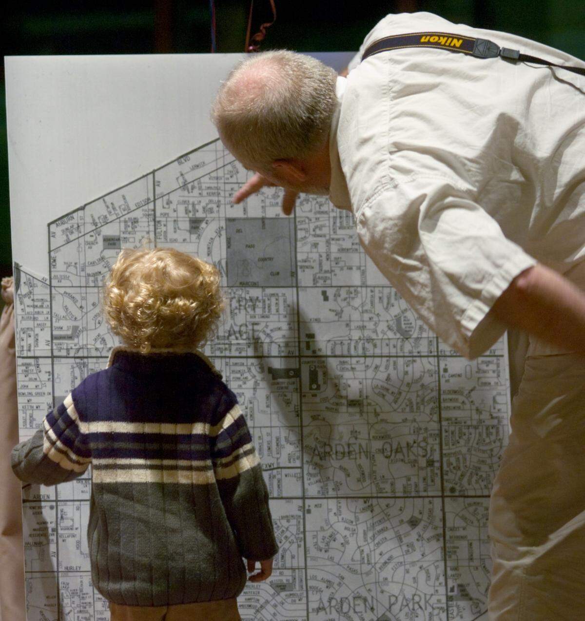 Charles Sanders, 2, examines a map of the proposed Arden Arcade city boundaries with the help of godfather Tab Berg at the Arcade Church in 2007, during a petition drive party at the church by the Arden Arcade Incorporation Committee. The petition would put the question of cityhood on the ballot for the community in Sacramento County.