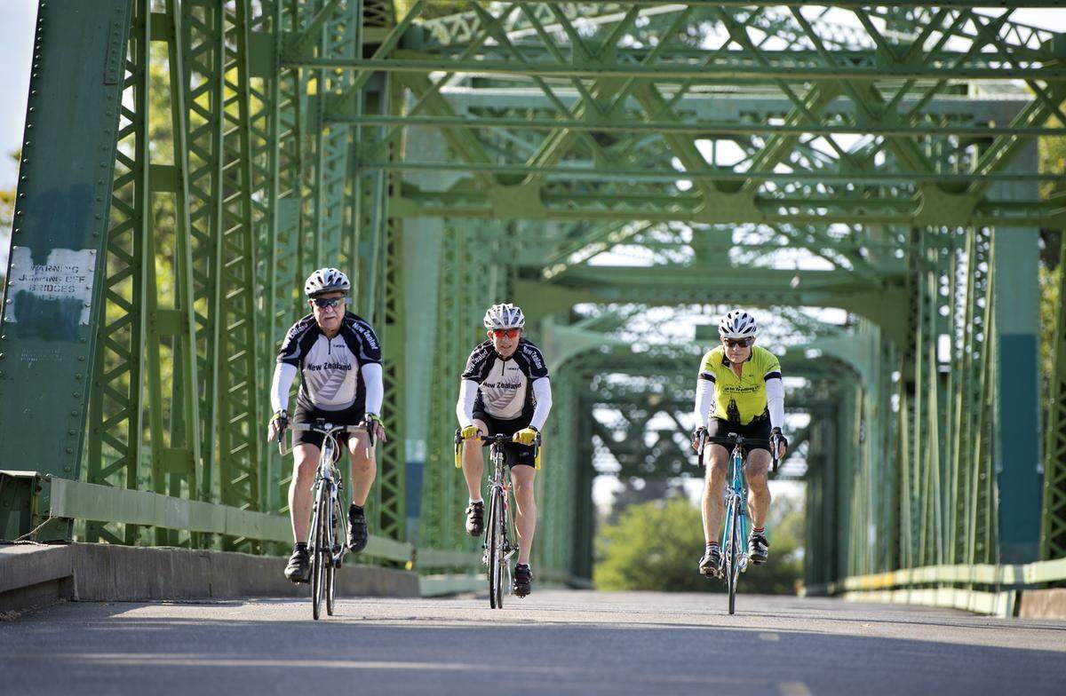 Dan Gorfain, 70, left, and his cycling pals Howard Sarasohn, 72, middle, and Dave Brubaker, 68, ride across the Jibboom Street Bridge on Tuesday, July 23, 2013 in Sacramento, Calif. The riding seniors are poster boys for the value of active aging. The retirees are fit and active, and they believe in playing through back pain and worse: After they cycled hundreds of miles together around New Zealand in 2010, Gorfain came home and underwent a quadruple bypass three days later. And then he got back on his bike.