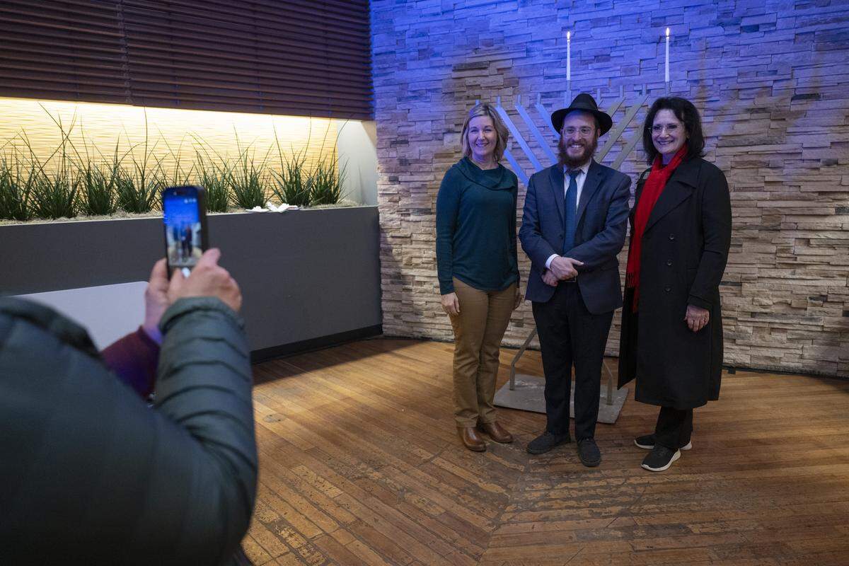 Rabbi Yossi Korik, the executive director of Chabad of Placer County, poses for a photo with Placer County supervisors Bonnie Gore, left, and Suzanne Jones, right, after a menorah lighting on the first night of Hanukkah at the Westfield Galleria in Roseville on Sunday.