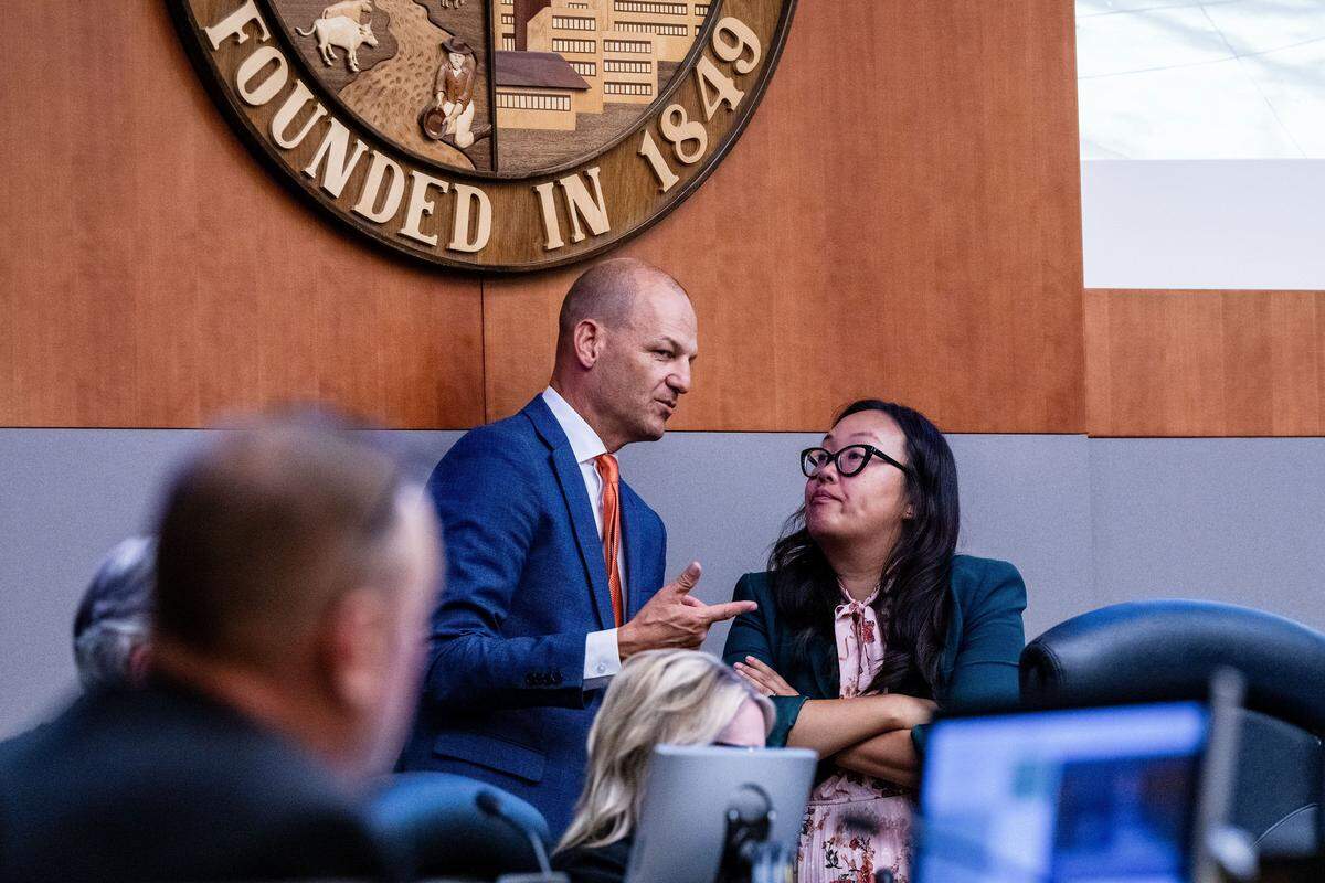 Sacramento Mayor Kevin McCarty, who voted in favor of charging fees for homeless seniors to live in micro-communities, chats with Councilmember Mai Vang, who voted against the fees, at a City Council meeting on Tuesday.