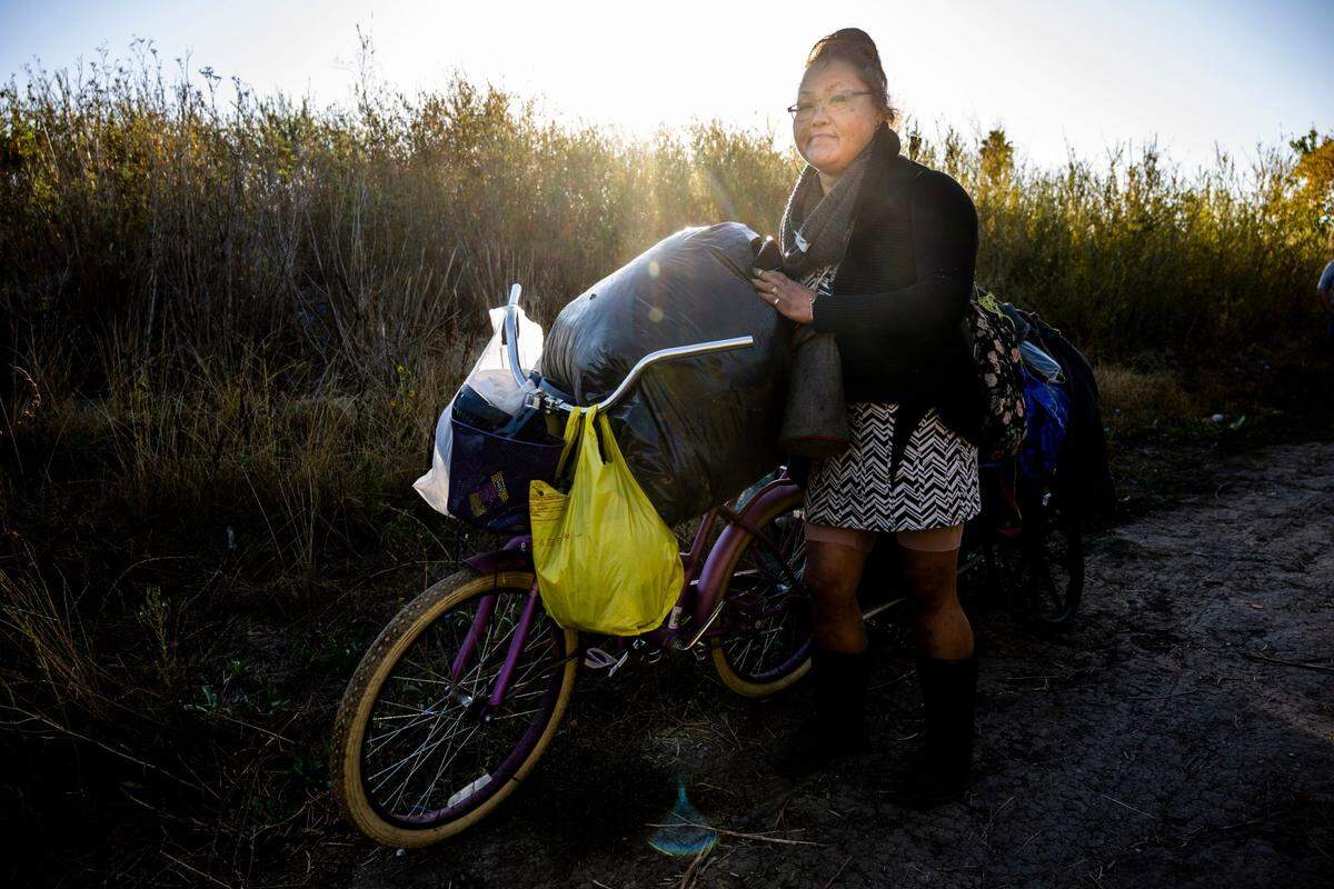 Sane Thao, 44, leaves her camp site on Morrison Creek in south Sacramento on Oct. 6 as the longtime camp is demolished by the Department of Utilities so levee work can begin.