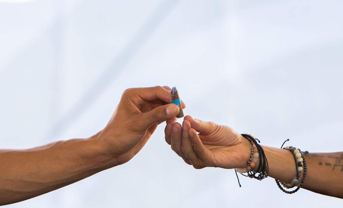 Michael Johnson, left, hands a prerolled joint to his mother, Caprice Lacy, in the cannabis consumption lounge on Tuesday, July 16, 2024, during the California State Fair in Sacramento.