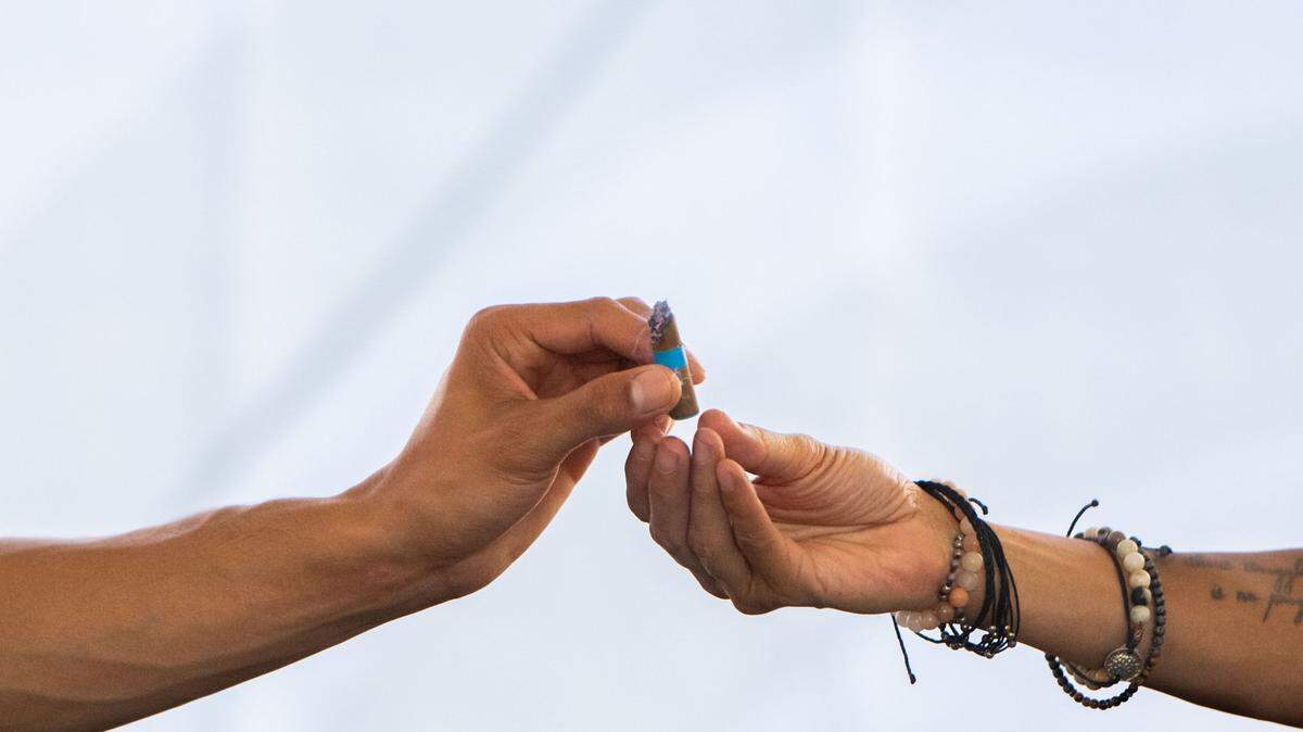 Michael Johnson, left, hands a prerolled joint to his mother, Caprice Lacy, in the cannabis consumption lounge on Tuesday, July 16, 2024, during the California State Fair in Sacramento. “It’s such a chill vibe,” Johnson said. “It’s a pretty cool space to be in.”
