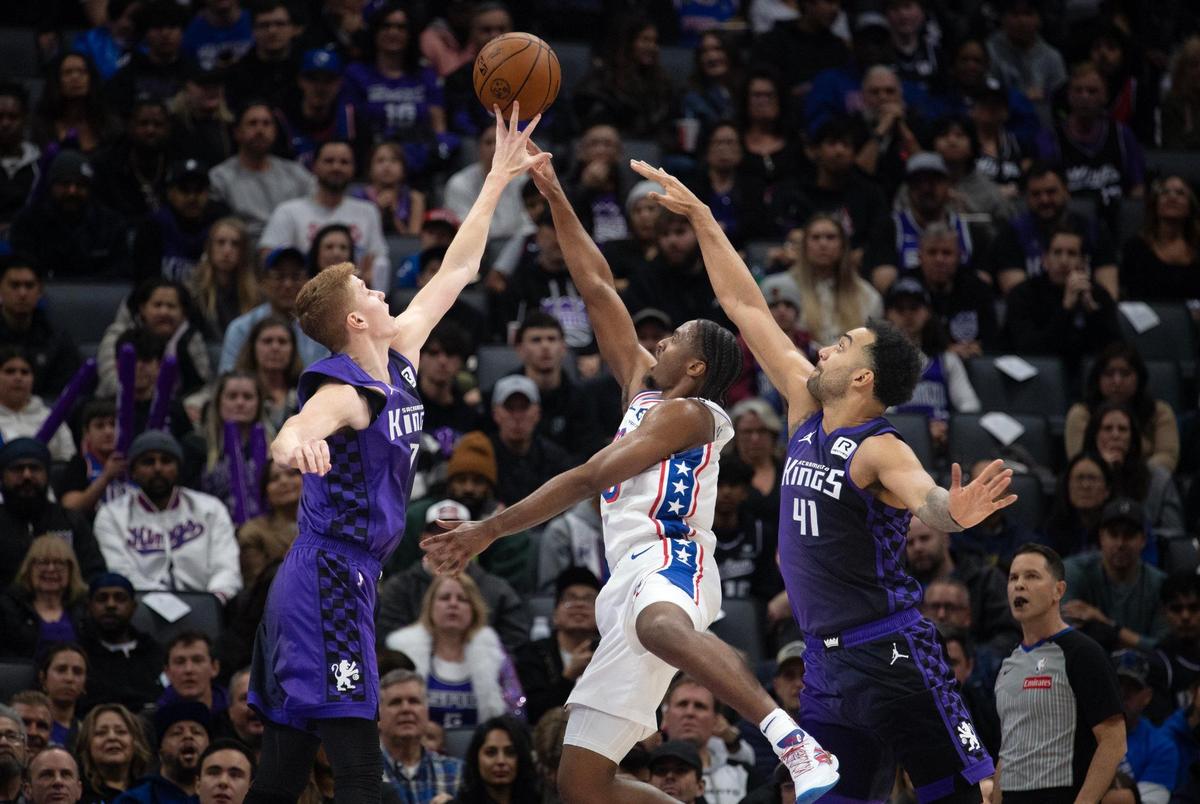 Sacramento Kings guard Kevin Huerter (9) blocks the shot of Philadelphia 76ers guard Tyrese Maxey (0) as forward Trey Lyles (41) helps out on defense in the first half on Wednesday, Jan. 1, 2025 at Golden 1 Center.