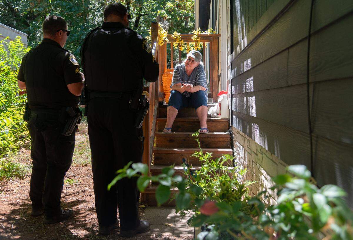 Sacramento County deputies speak with Hope Messatzzia at her mobile home in Forest Ranch on Friday, July 26, 2024. The officers offered to assist Messatzzia, but she told them she was choosing to stay in her home for the time being despite having no gas in her car and no electricity.