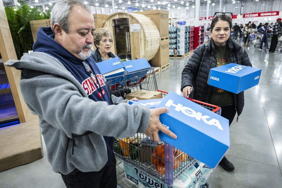 David Lobato and his wife Maria prepare to purchase Hoka tennis shoes with his mother-in-law Julia Parra during the grand opening of the Costco on Baseline Road on Friday. Each customer was allowed to purchase two pairs.