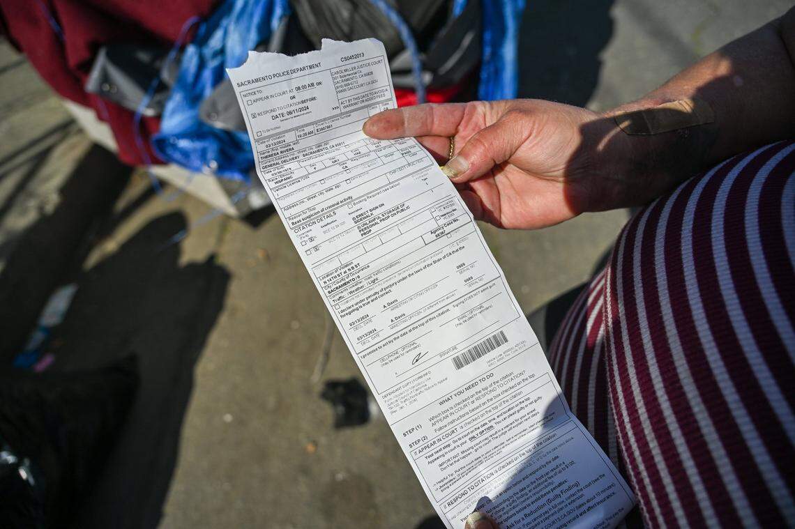 Theresa Rivera holds her citation from the Sacramento Police Department on March 13, 2024. According to court records, she now owes $333 after missing her court date. She fears the misdemeanor will make it even harder to find housing, as it’s viewable to prospective landlords.