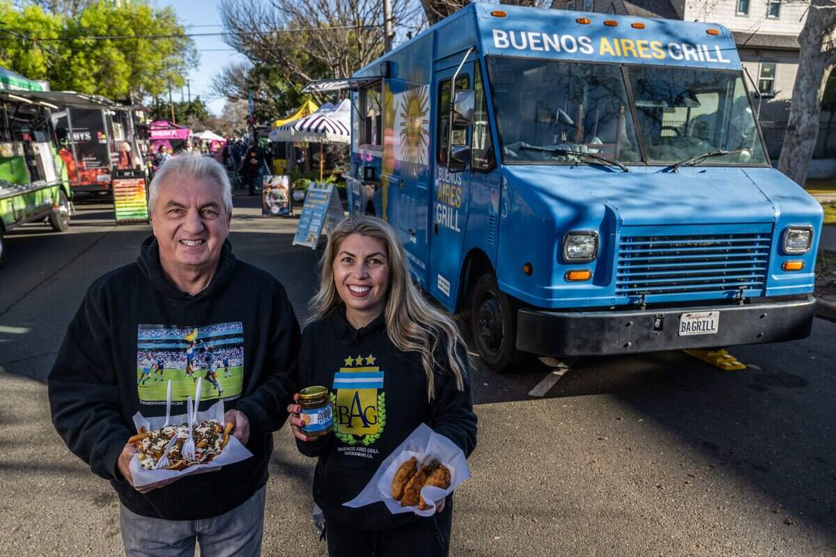 Ruben Bozzalla and his daughter Estefania Bozzalla hold some of the food they serve from their Buenos Aires Grill food truck on earlier this month at the Midtown Farmers Market in Sacramento. Ruben is holding their best sellering “messy” fries topped with chicken, mayonnaise and tomatoes and Estefania holds empanadas and a jar of chimichurri.