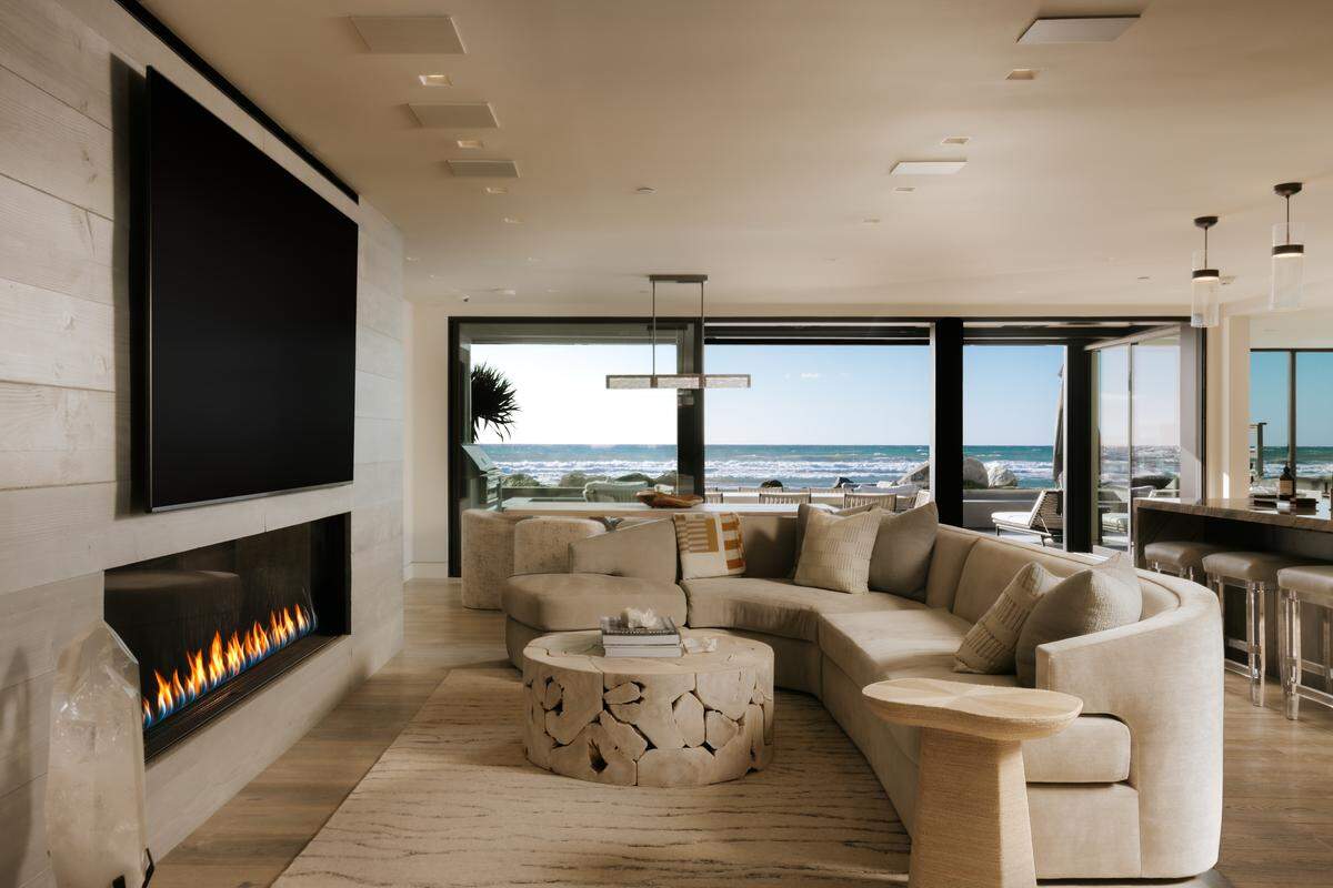 An entertainer’s bar, wine cellar and chef’s kitchen flow into a family room anchored by an oversized fireplace.