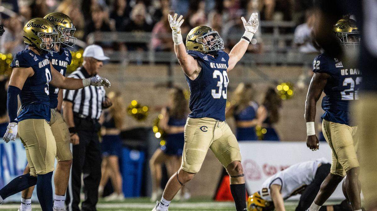 UC Davis Aggies linebacker Porter Connors (39) celebrates an interception in the second half as Idaho Vandals quarterback Jack Wagner (10) bends on the field on Saturday at UC Davis Health Stadium.