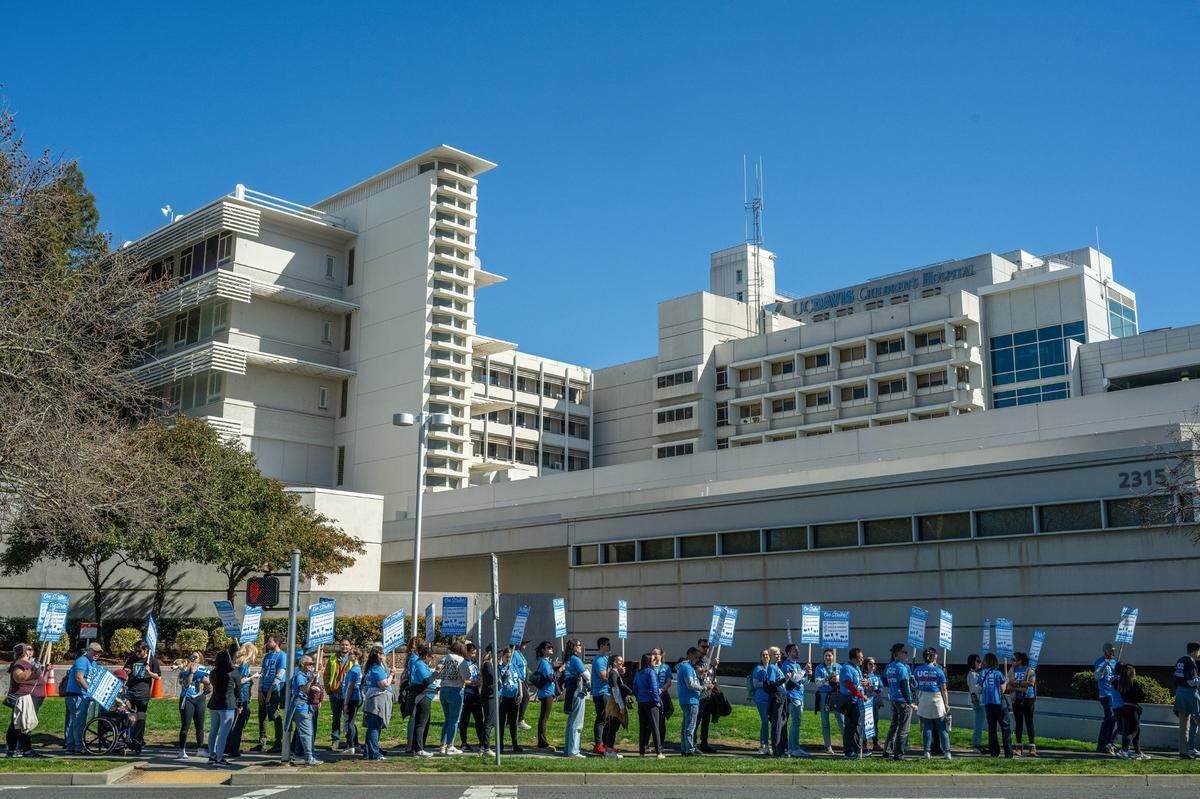 Picketers march along Stockton Boulevard in Sacramento at the UC Davis Medical Center toward a rally on Wednesday.
