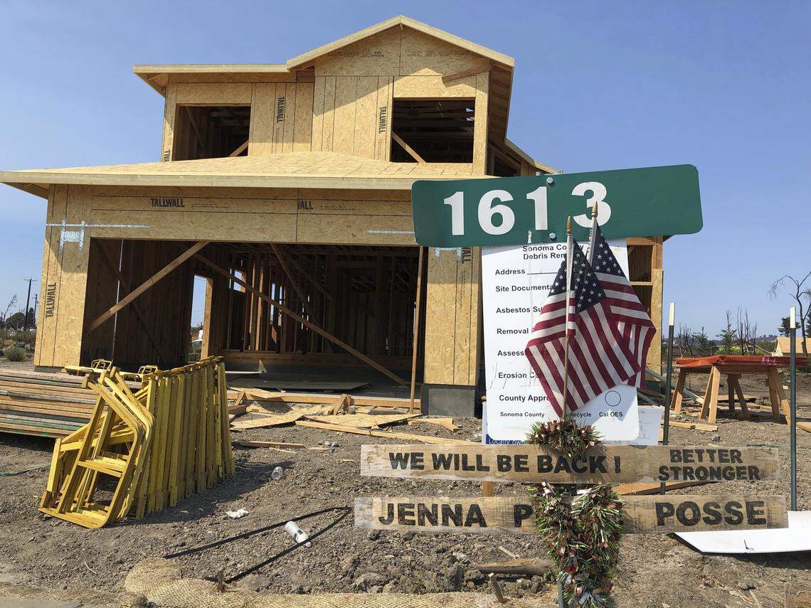 Signs and flags mark the partially rebuilt home of Debbie and Rick Serdin in the Coffey Park neighborhood of Santa Rosa in August 2018. The neighborhood is not subject to state building standards for high-risk fire areas.