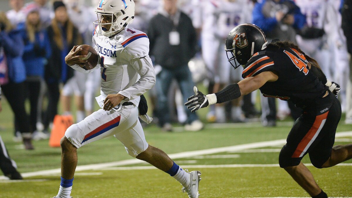 Folsom quarterback Kaiden Bennett, left, scampers past Central’s Shando Lopez for a touchdown on a keeper play during their NorCal Regional Division 1 championship game at Koligian Stadium in Fresno on Friday, Dec. 7, 2018.