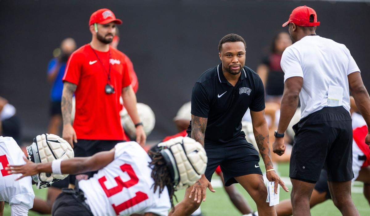 UNLV offensive coordinator Brennan Marion talks with coaches and players during football practice at the Fertitta Football Complex field in Las Vegas in August.