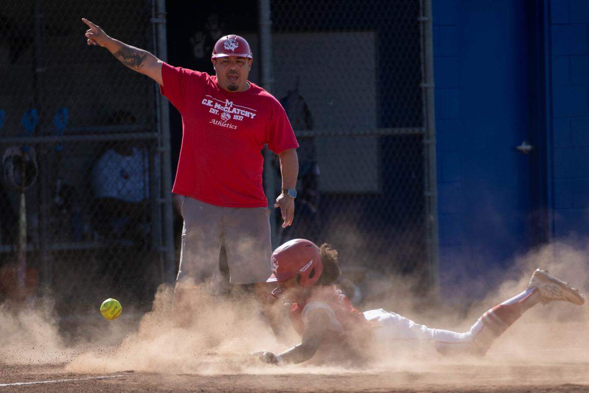 The McClatchy Lions’ Jayeliza Rogers slides into third base and then scores against the Folsom Bulldogs during a first-round CIF Sac-Joaquin Section Division I softball playoff game at Folsom High School on Wednesday.