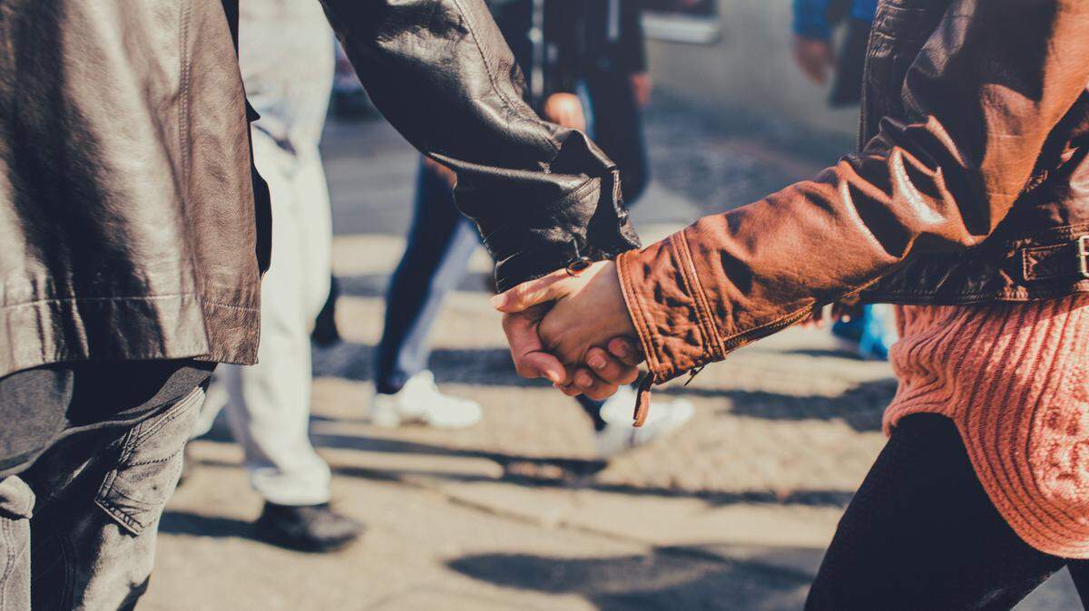 Young couple going hand in hand through the street.
