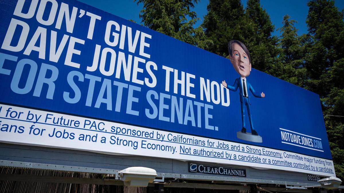 A campaign billboard on Sutterville Road in Sacramento depicts Dave Jones, a candidate for state Senate District 8, as a bobblehead on Wednesday, May 11, 2022. Jones is running against City Councilwoman Angelique Ashby.