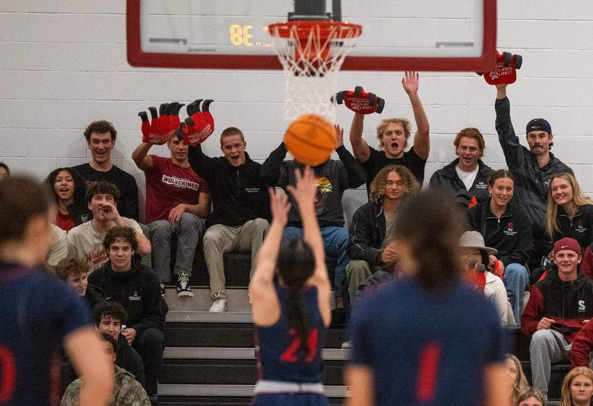 Sierra College Wolverines students wave their claws as a Santa Rosa Junior College player attempts a free throw during the first game held in the new gymnasium at the Rocklin campus Tuesday.