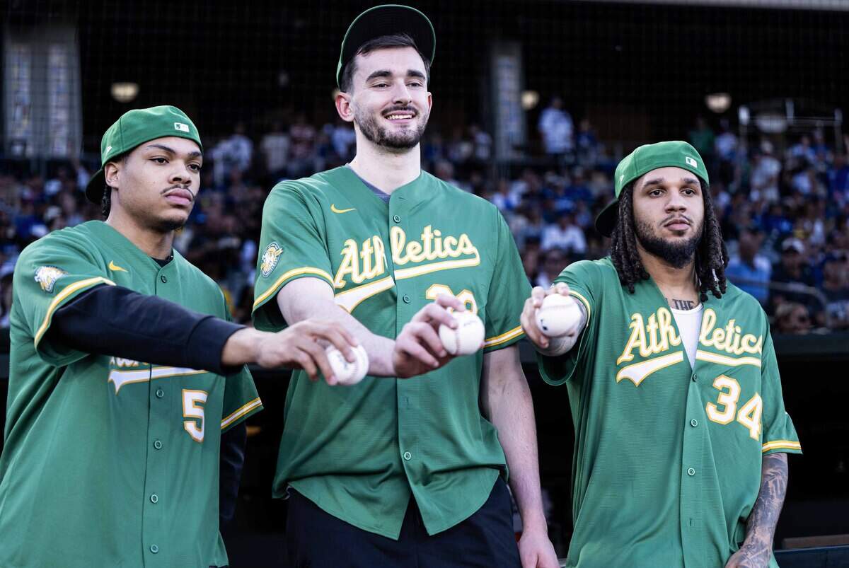 New Sacramento Kings players Darius Acuff Jr., Alex Karaban, and Emanuel Sharp hold baseballs before throwing the first pitch before a game between the Athletics and the Los Angeles Dodgers at Sutter Health Park on Monday.