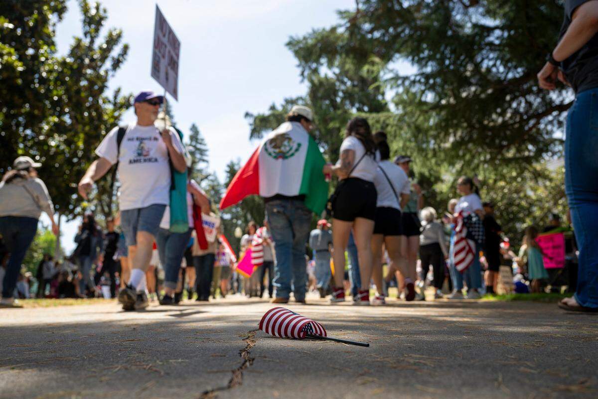 An American flag sits on the ground as demonstrators pass by at the state Capitol during the “No Kings” protest against the Trump administration in downtown Sacramento on Saturday.