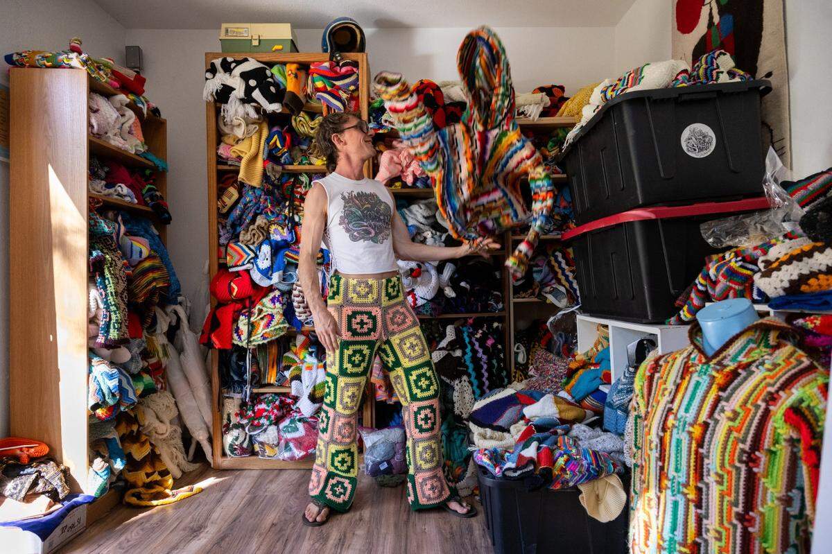 Fashion designer Schuyler Ellers tosses a hoodie made from found crochet blankets at his studio near Nevada City earlier this month. His clothing line, Lord von Schmitt, is made from crochet blankets and throws.