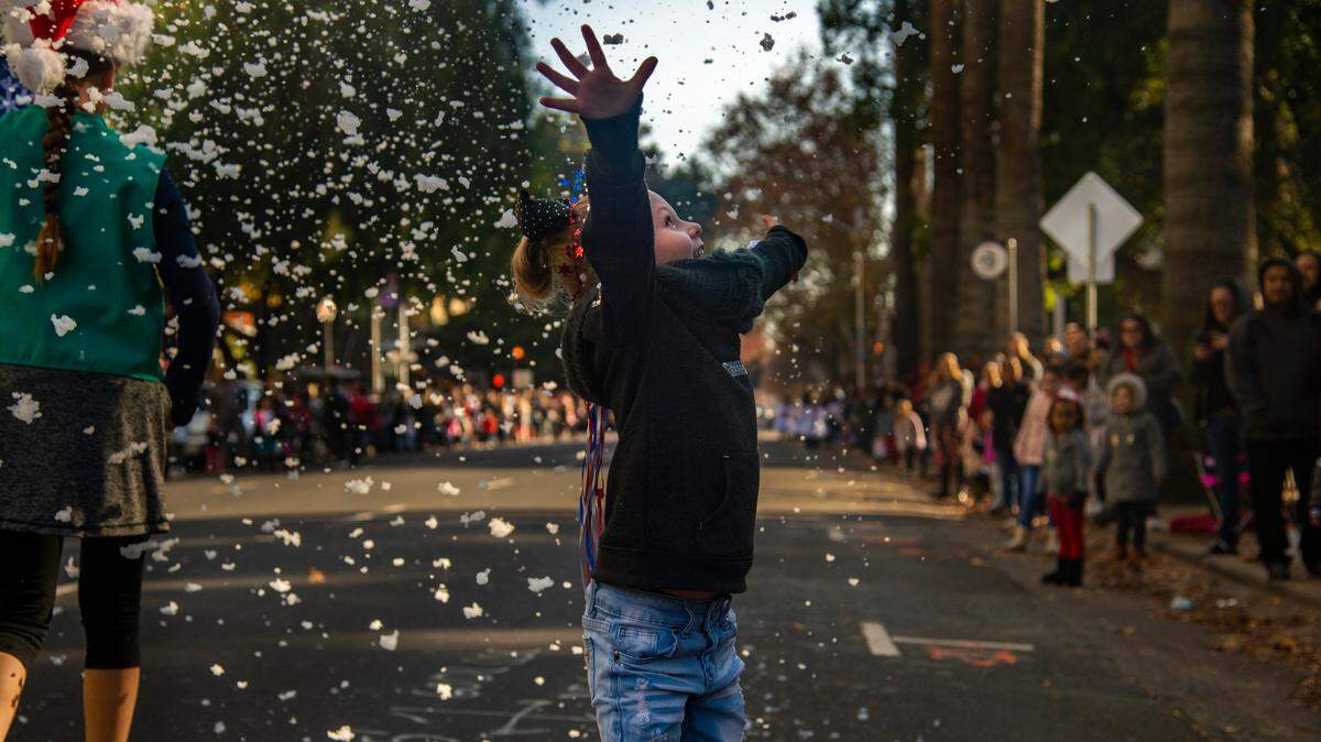 Tessa Frank, 6, plays in the faux snow at the Sacramento Santa Parade in Downtown Sacramento, Saturday, Dec. 8, 2018 around Capitol Park.