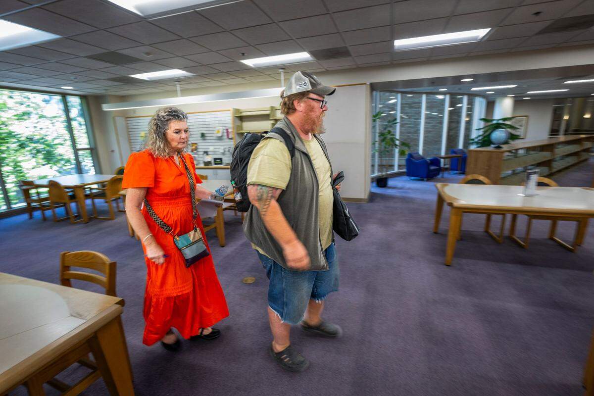 Maria Montano, a social worker at the Sacramento Public Library, leaves the library with Paul Jackson for an optometry appointment on June 10.