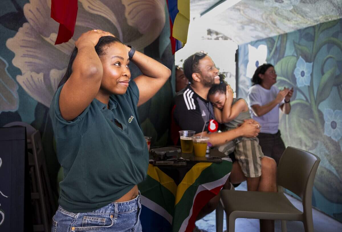 Starr Modise reacts to the first goal scored by Mexico, as she and her husband KG Mots and daughter Kago Mots, 4, attend a World Cup watch party at Garden at the Line in Sacramento on Thursday. "It’s a different experience seeing it from here after watching the World Cup in South Africa when they opened against Mexico in 2010,” Modise said.