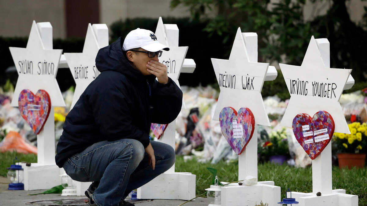 A man pauses Monday in front of Stars of David with the names of those killed in a deadly shooting at the Tree of Life Synagogue in Pittsburgh.