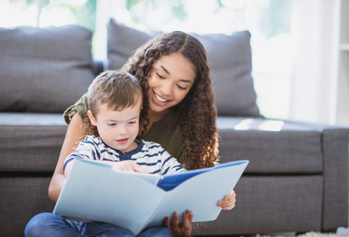 A nanny reads to a young boy