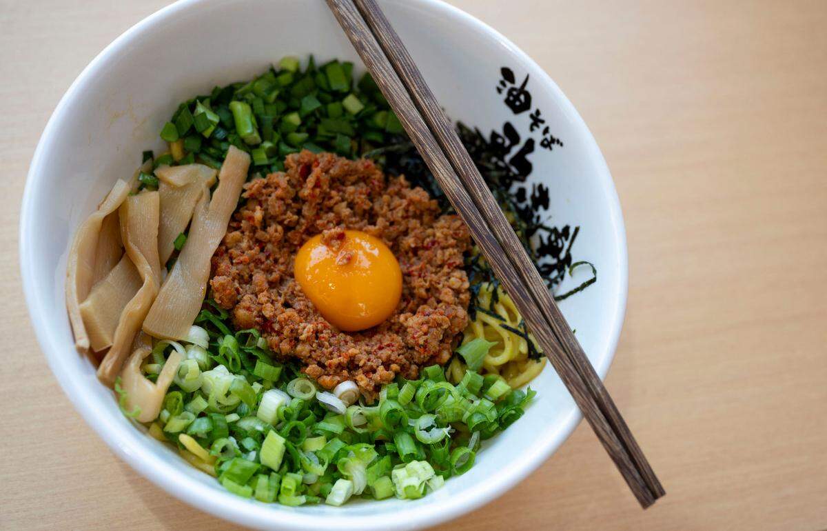 Kajiken’s signature dish, homura abura soba, has spicy minced pork, green onions, bamboo shoots, seaweed, fish powder, chives and raw egg yolk.