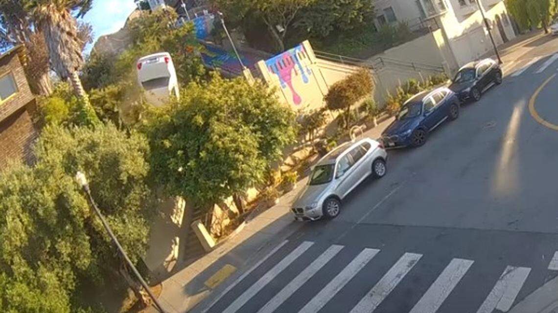Security video shows two people dashing away after a car flips down stairs onto a San Francisco sidewalk, California officials say.