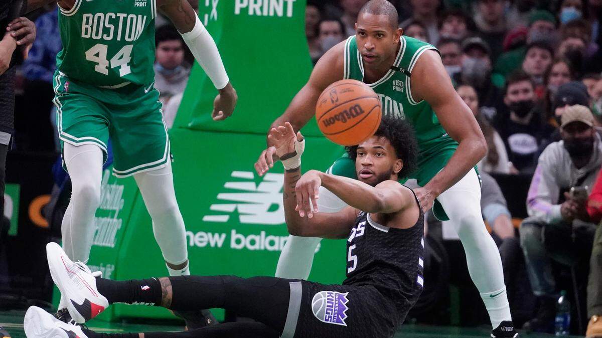 Sacramento Kings forward Marvin Bagley III, on floor, passes the ball while pressured by Boston Celtics center Al Horford, top, during the first quarter of an NBA basketball game, Tuesday, Jan. 25, 2022, in Boston. (AP Photo/Charles Krupa)
