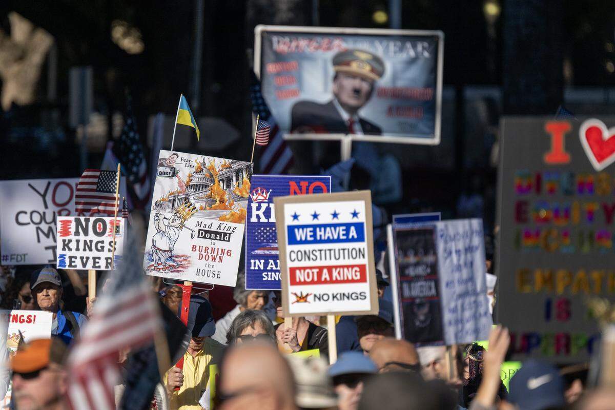 Demonstrators hold signs during the "No Kings" protest at the state Capitol in Sacramento on Saturday, Oct. 18, 2025.