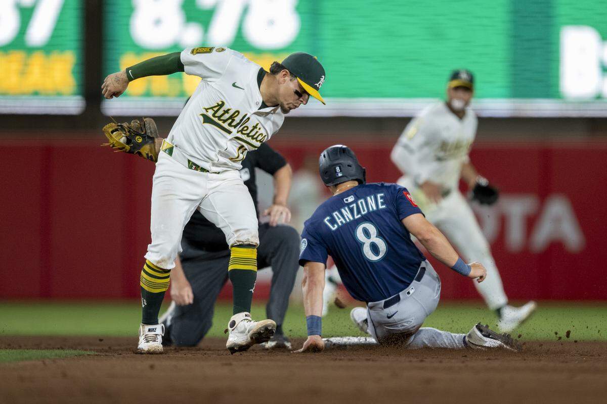 Athletics second baseman Luis Urías (17) attempts to apply a tag as Seattle Mariners outfielder Dominic Canzone (8) steals second base in the ninth inning during a baseball game at Sutter Health Park in West Sacramento on Monday.