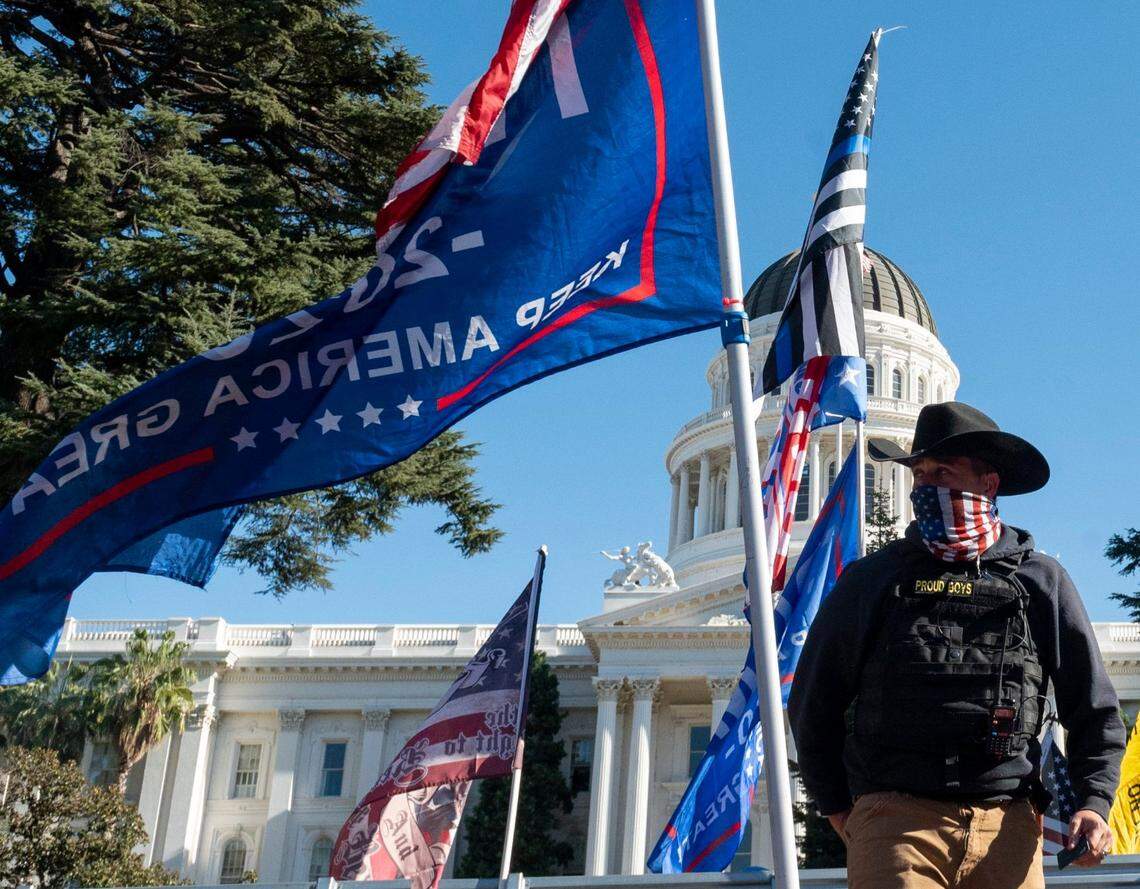 A member of the Proud Boys watches over a “Stop the Steal” protest at the state Capitol in November 2020, after news reports projected Joe Biden’s election as the 46th president of the United States.