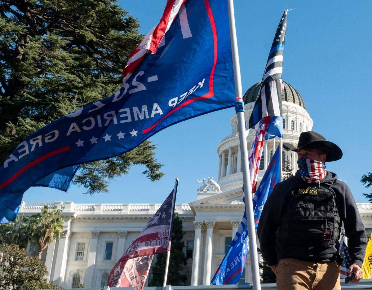 A member of the Proud Boys watches over a “Stop the Steal” protest at the state Capitol in November 2020, after news reports projected Joe Biden’s election as the 46th president of the United States.