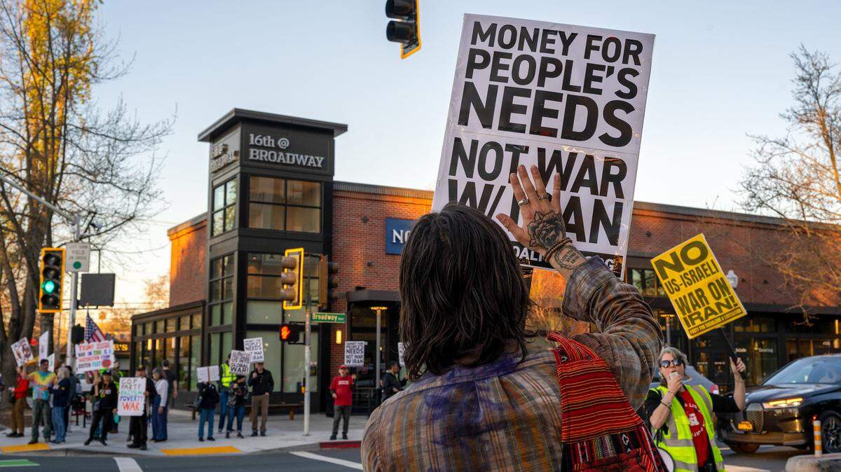 Demonstrators hold signs at the intersection of 16th Street and Broadway in Sacramento on Monday, March 2, 2026, while demonstrating against the U.S.-Israel war with Iran. Debates intensified over cap-and-invest’s role among state officials amid growing uncertainty over gas prices on Tuesday, March 3, 2026.