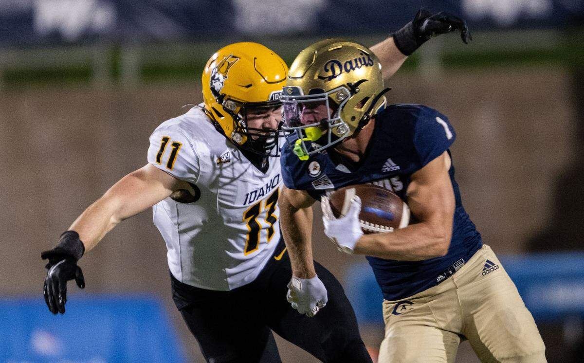 UC Davis Aggies wide receiver C.J. Hutton (1) is wrapped by Idaho Vandals linebacker Zach Johnson (11) on Saturday at UC Davis Health Stadium.