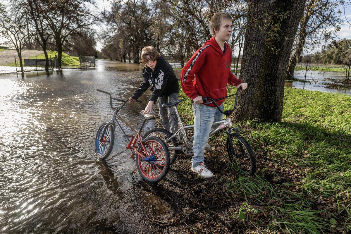Kaleb Hurley, 16, and David Clark, 15, of Rio Linda, turn their bikes around after encountering the flooded Sacramento Northern bike trail near Elkhorn Boulevard on Friday.