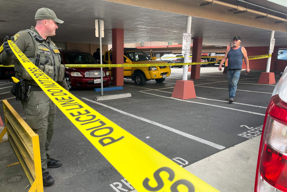 Sacramento Park Ranger Dobbs lifts police line tape as a witnesses exits the scene where a yellow Nissan pickup truck, its tire flattened in a police chase, sits abandoned in an Alhambra Boulevard parking lot on Friday.