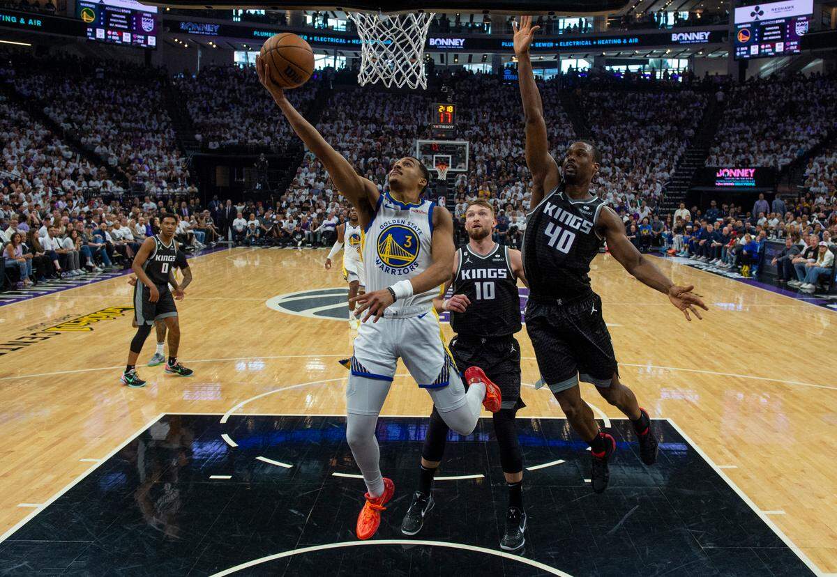 Golden State Warriors guard Jordan Poole (3) drives past Sacramento Kings center Domantas Sabonis (10) and Sacramento Kings forward Harrison Barnes (40)during Game 1 of the first-round NBA playoff series at Golden 1 Center on Saturday, April 15, 2023.