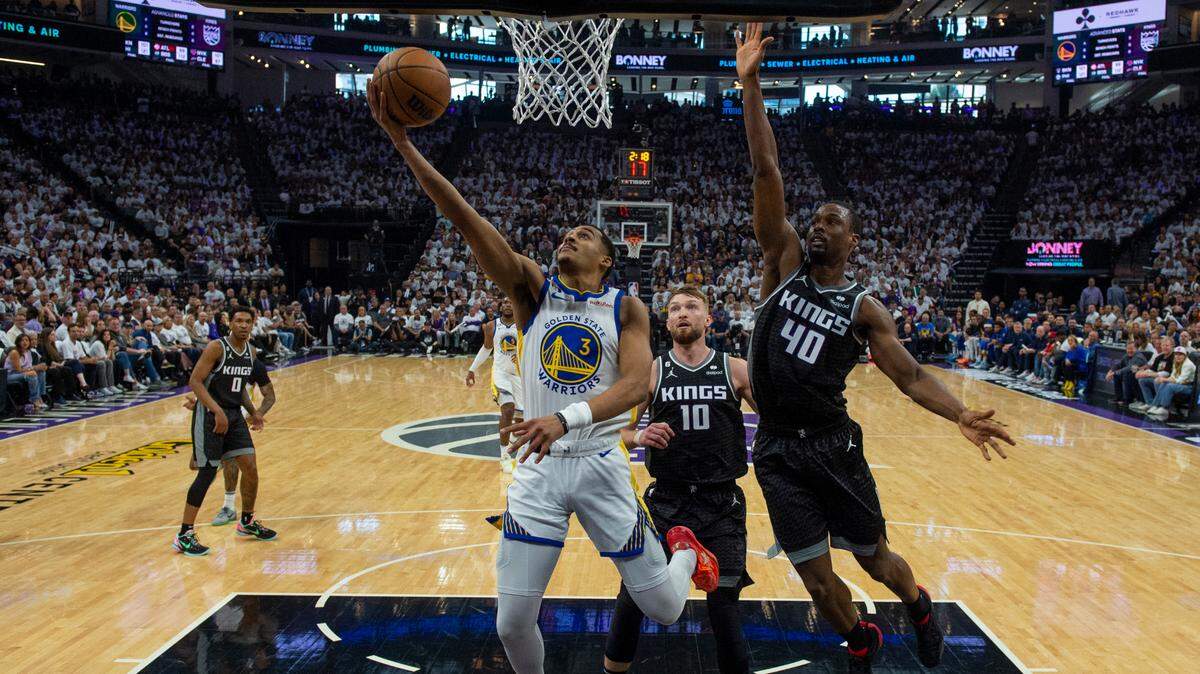Golden State Warriors guard Jordan Poole (3) drives past Sacramento Kings center Domantas Sabonis (10) and Sacramento Kings forward Harrison Barnes (40)during Game 1 of the first-round NBA playoff series at Golden 1 Center on Saturday, April 15, 2023.